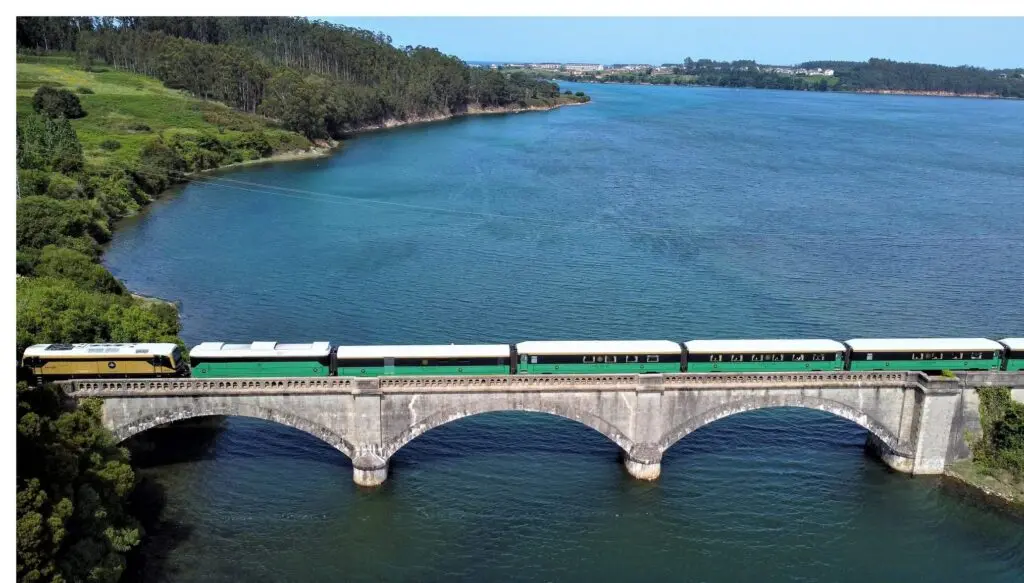 The Costa Verde Express on an arched bridge above a river
