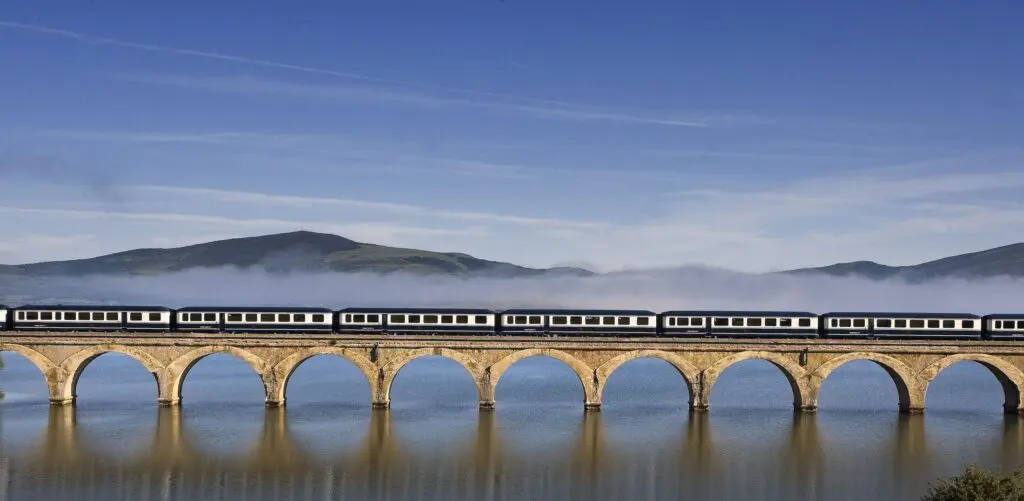 El Transcantábrico crossing a long viaduct above morning mist