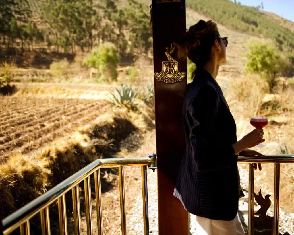 Guest with a drink on the Hiram Bingham observation car