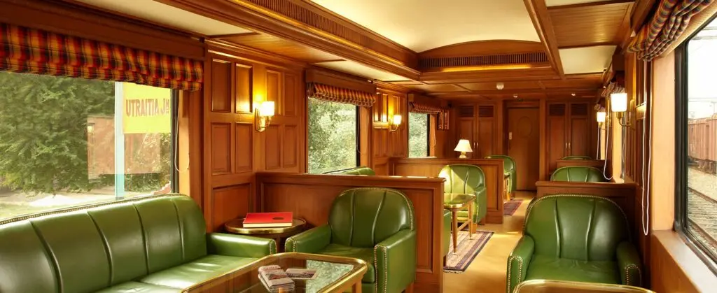 Rajah Club lounge car with wood panelling and green leather sofas and armchairs