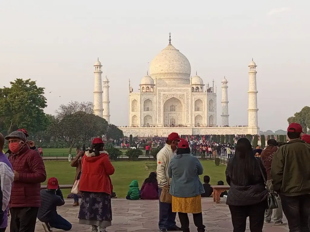 The Taj Mahal in Agra seen across the gardens with visitors in the foreground